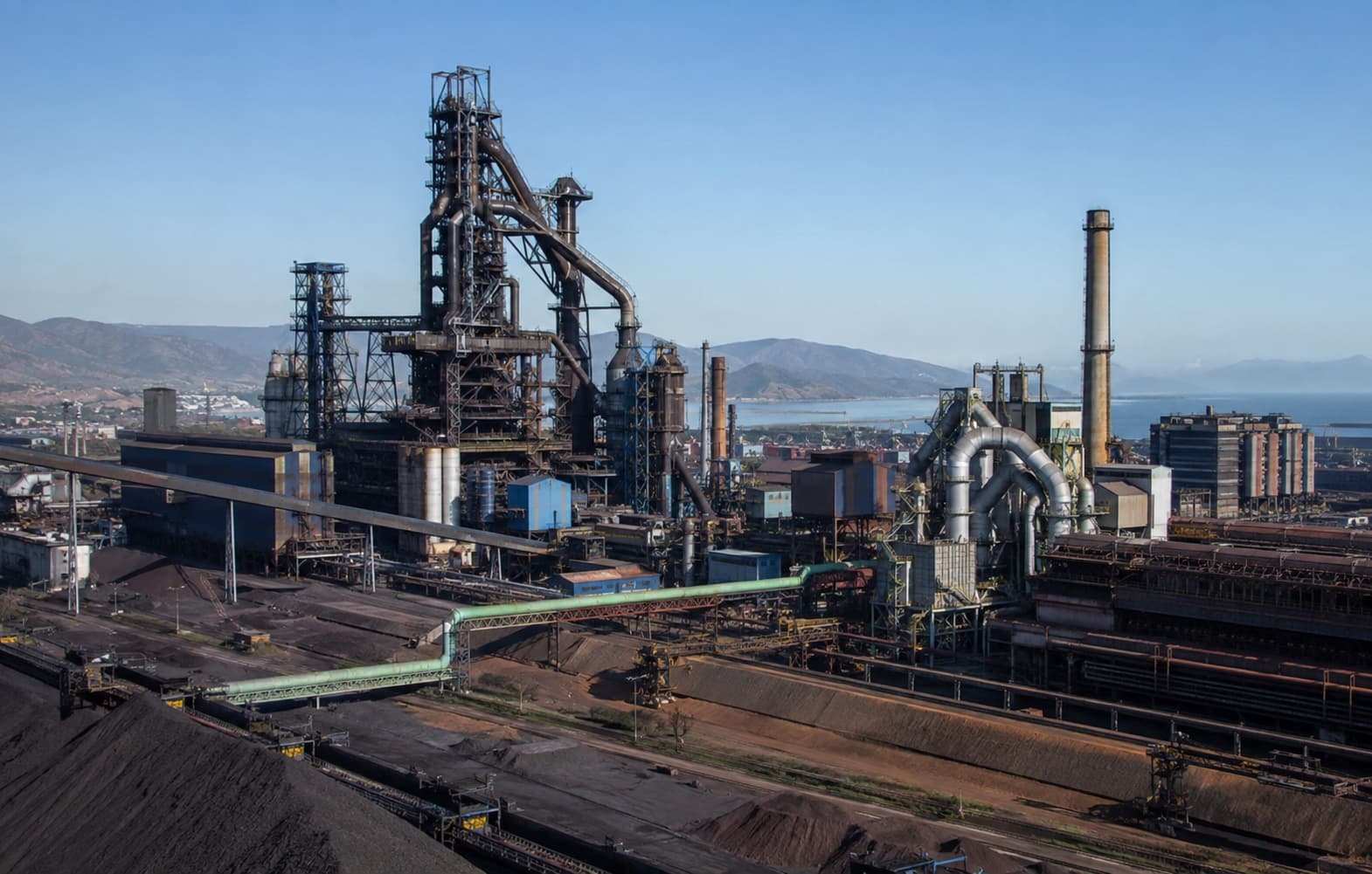 Integrated iron and steel production complex with blast furnace and rolling infrastructure